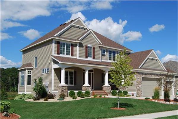 4-bedroom Country style Traditional home design with large white porch columns and stacked-stone accents.