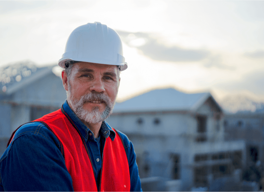 Home builder on job site reviewing new house construction plans and home construction